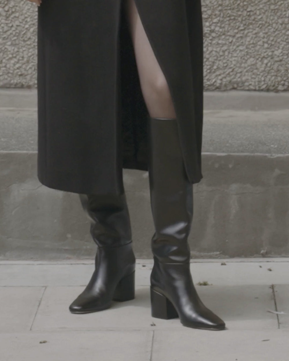 Model walking in Dear Frances Alma Knee Boots in black leather, showing the full-height shaft, square toe and block heel